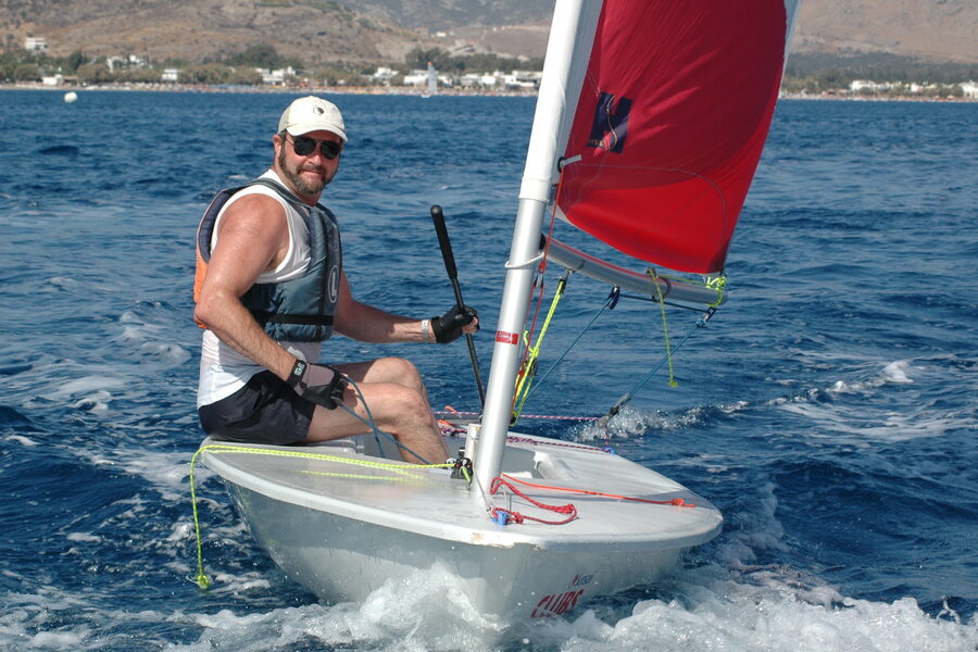 A sailor racing a Laser/ILCA dinghy